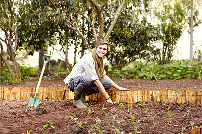 Buy stock photo Handsome young guy planting some seedlings in his vegetable garden