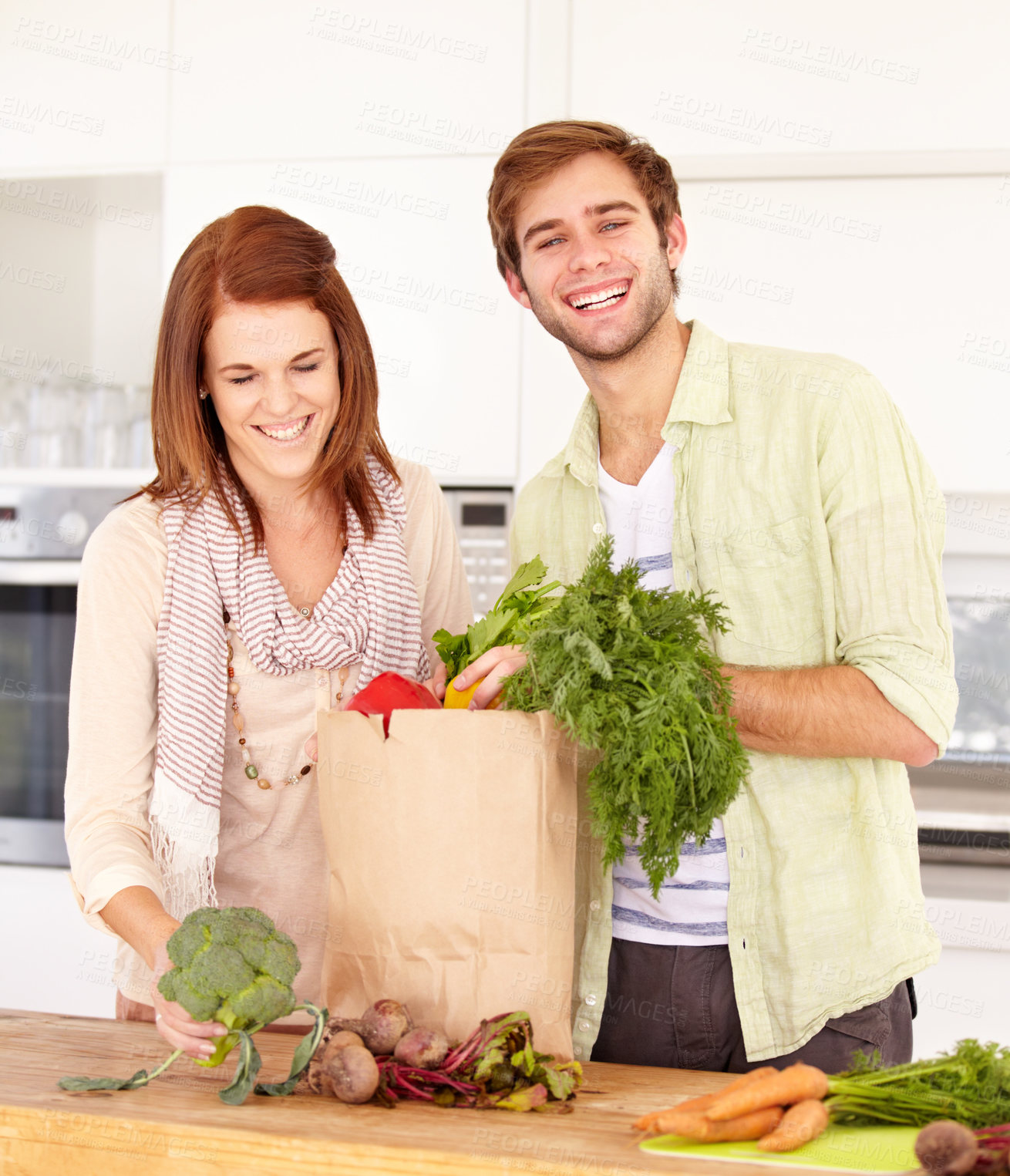 Buy stock photo Couple, kitchen and vegetables for grocery shopping, unpacking and smile for food, nutrition and cooking. Man, woman and healthy in home, vegan, diet and package for vegetarian, produce and fresh