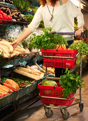 Buy stock photo Cropped image of a woman pushing a trolley in the grocery store