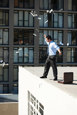 Buy stock photo Business, financial freedom and money rain with a man in the city, throwing cash during a summer day. Finance, success or raining dollars with an employee on the roof of a building in an urban town