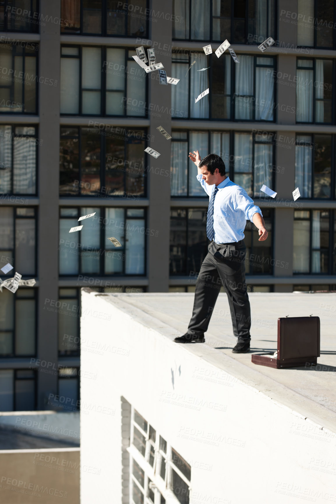 Buy stock photo Business, financial freedom and money rain with a man in the city, throwing cash during a summer day. Finance, success or raining dollars with an employee on the roof of a building in an urban town