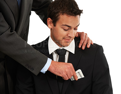 Buy stock photo A smart businessman looking at his pocket while another man places money in it