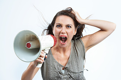 Buy stock photo An angry young woman screaming through a loudspeaker