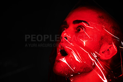 Buy stock photo Man, red plastic and suffocate in studio isolated on a black background mockup. Polyethylene, film and person with depression, fear and anxiety, stress and mental health crisis, psychology and neon