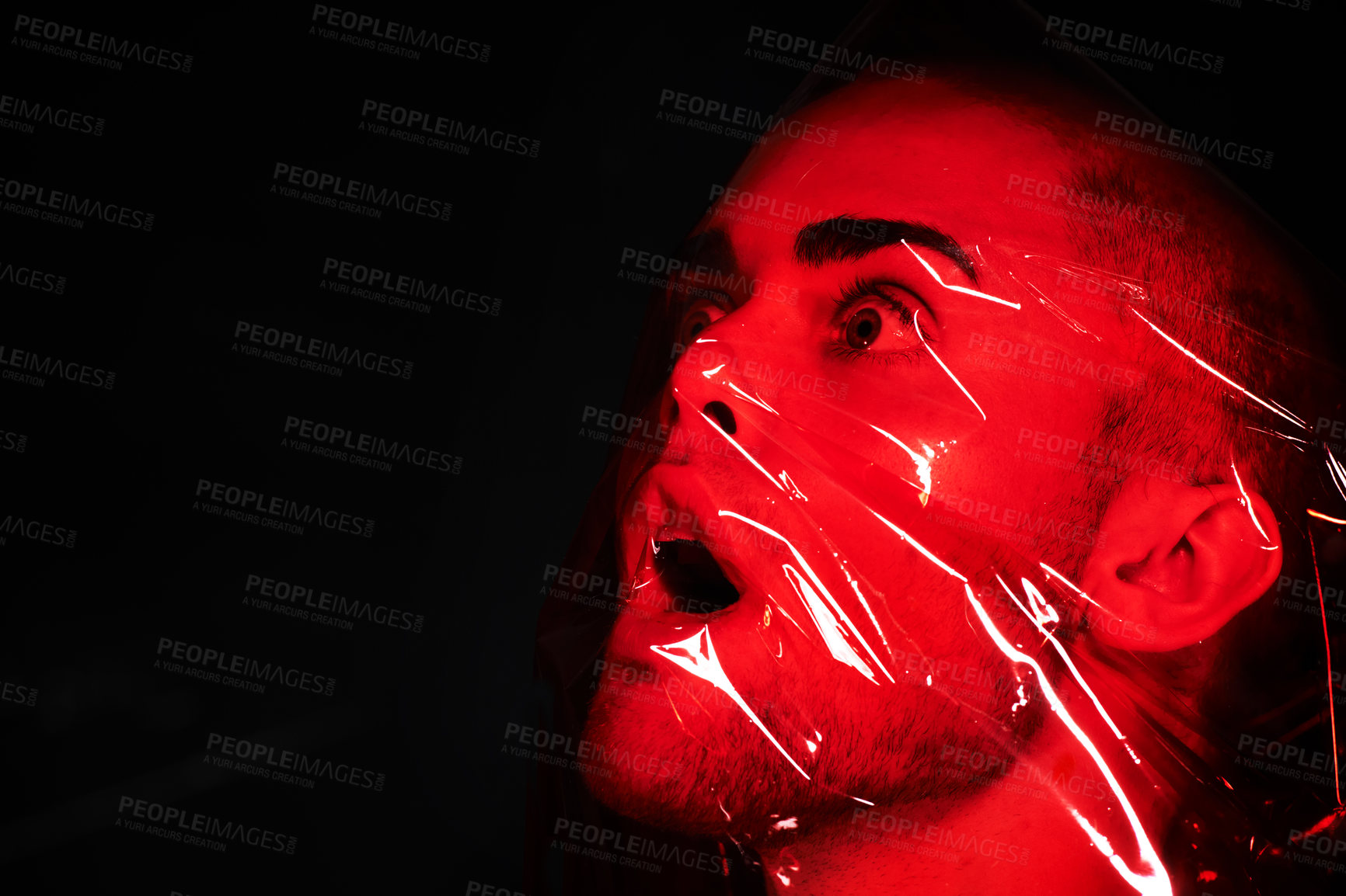 Buy stock photo Man, red plastic and suffocate in studio isolated on a black background mockup. Polyethylene, film and person with depression, fear and anxiety, stress and mental health crisis, psychology and neon