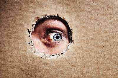 Buy stock photo Closeup, cardboard and eye spy on hole, peek and search on mockup space. Face, macro and man peeping through paper board for secret, security and watch for surveillance, discover mystery and privacy