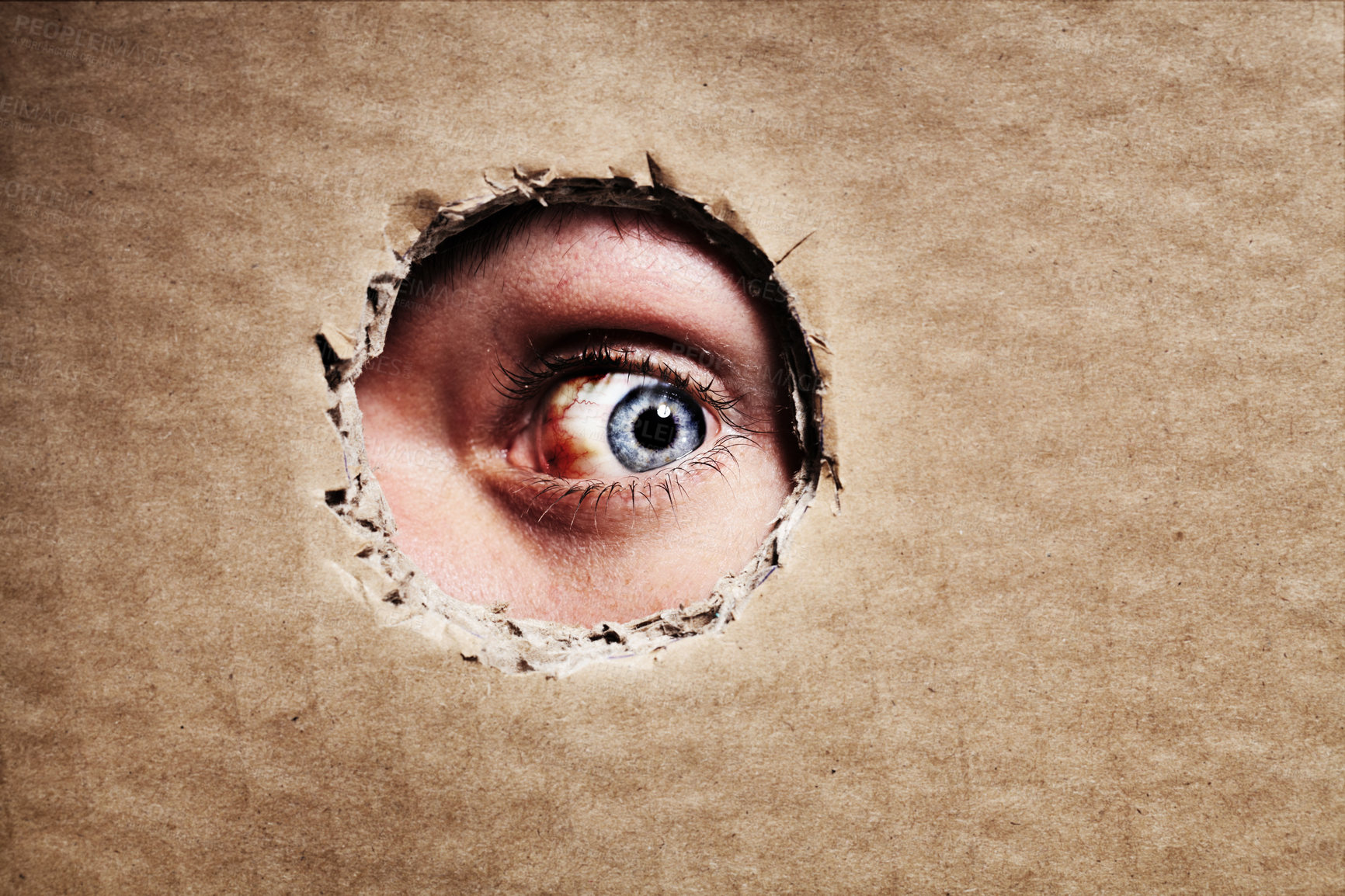 Buy stock photo Closeup, cardboard and eye spy on hole, peek and search on mockup space. Face, macro and man peeping through paper board for secret, security and watch for surveillance, discover mystery and privacy