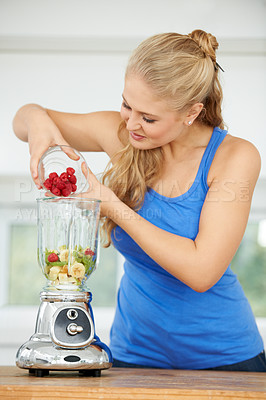 Buy stock photo Attractive young woman making a fruit smoothie