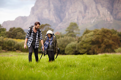 Buy stock photo Couple, holding hands and hiking in field with travel and fitness, vacation or date with people in relationship. Environment, trekking and adventure with nature or park, bonding with love outdoor