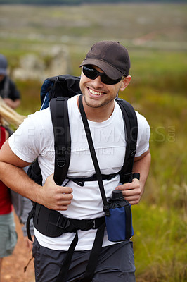 Buy stock photo Man with smile, backpack and friends on hiking adventure in mountain with nature, freedom or wellness. Travel, trekking and person in countryside with happy people on natural outdoor journey together