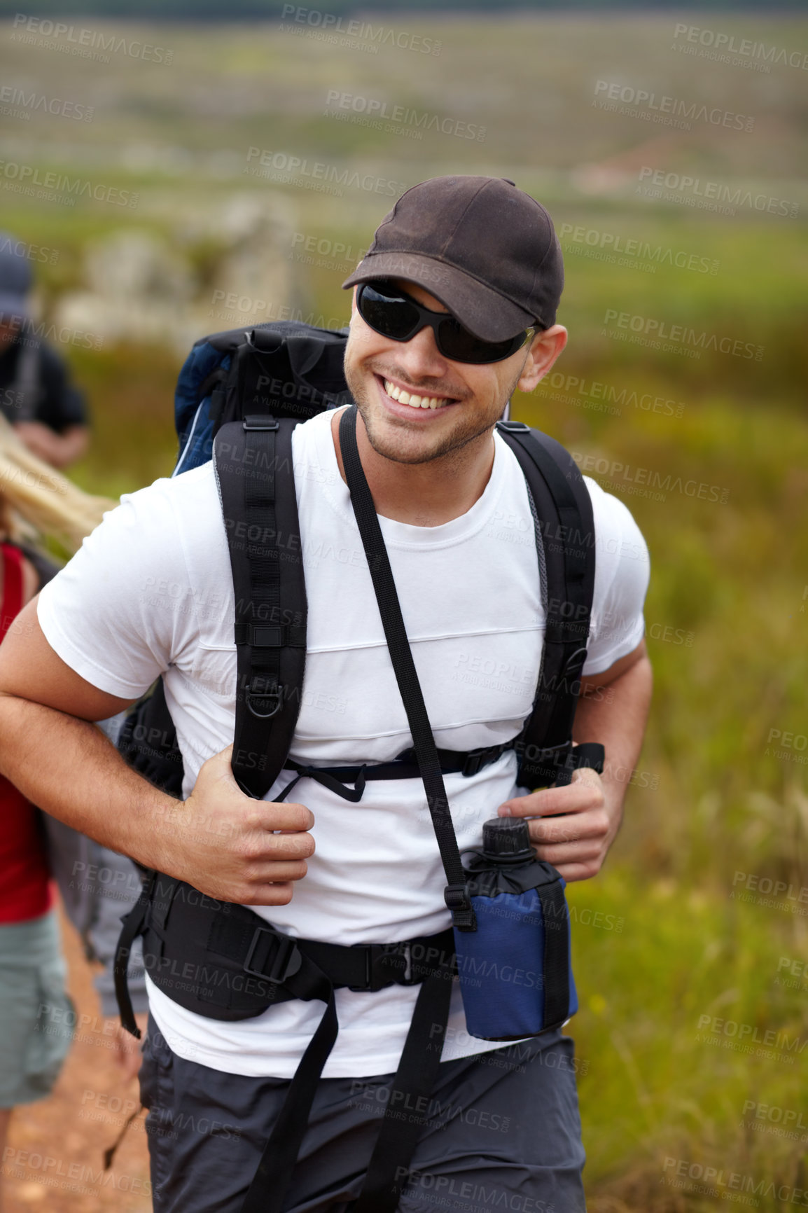 Buy stock photo Man with smile, backpack and friends on hiking adventure in mountain with nature, freedom or wellness. Travel, trekking and person in countryside with happy people on natural outdoor journey together