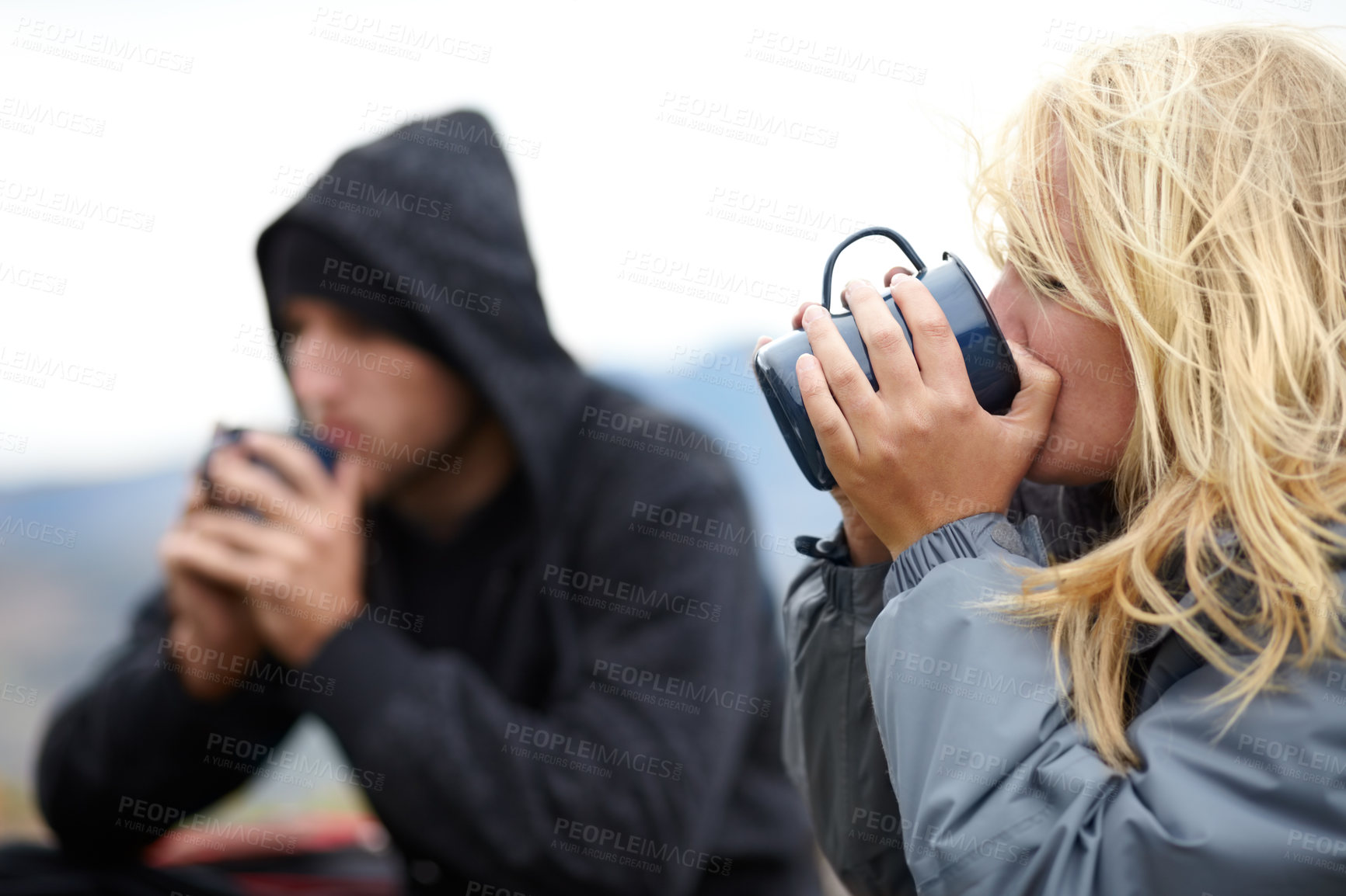 Buy stock photo A young couple taking a coffee break while on their hike together