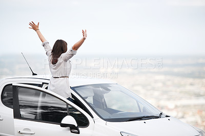 Buy stock photo Unknown woman with her arms raised while enjoying the scenic landscape during a road trip. One happy woman feeling free while traveling alone during the weekend. Exploring and adventure while driving