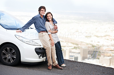Buy stock photo Happy young couple standing alongside their car while overlooking a grand view