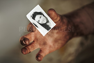 Buy stock photo A dirty hand holding a black and white picture of a beautiful woman