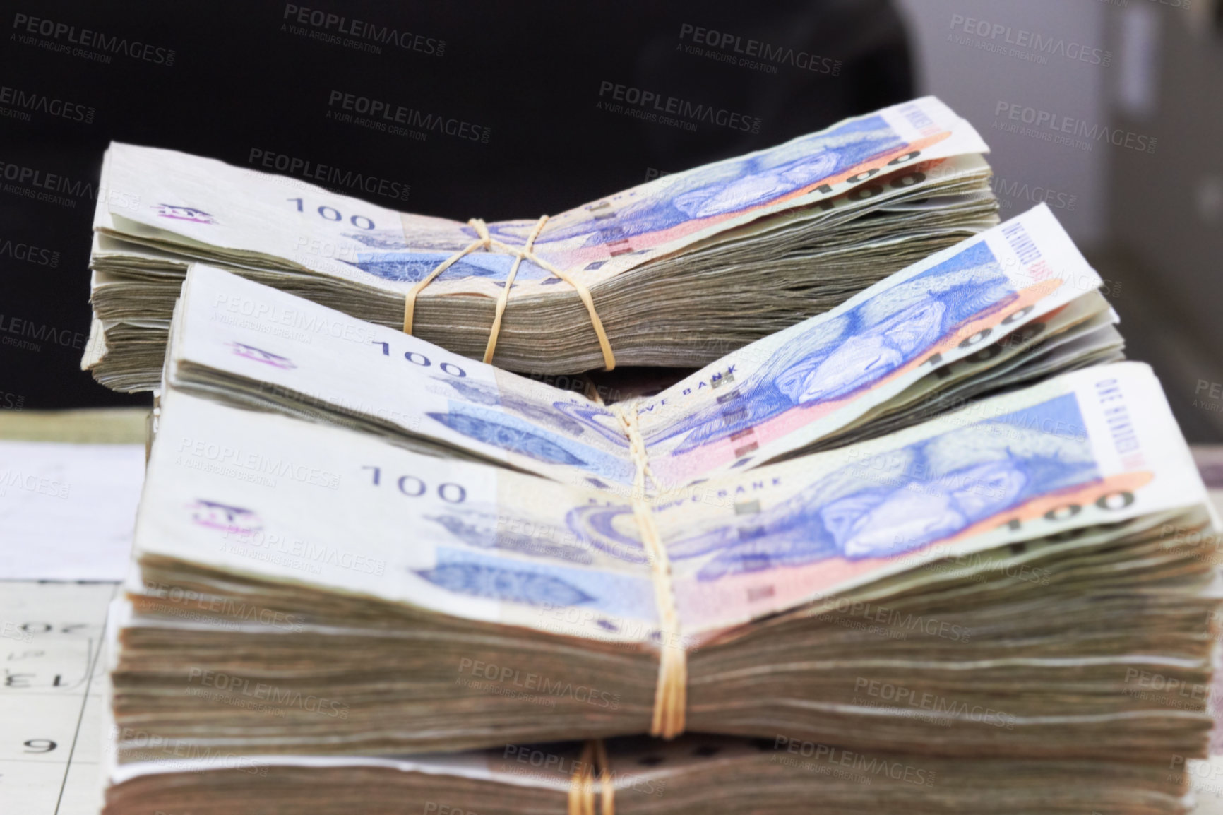 Buy stock photo Shot of money tied up and stacked on the table