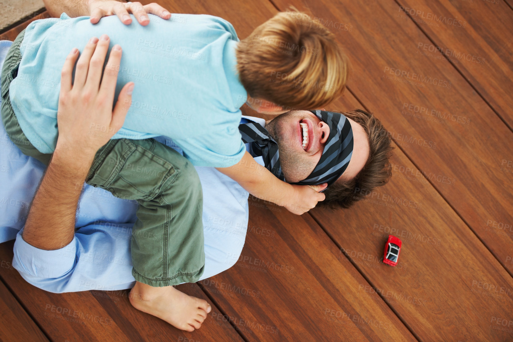Buy stock photo Man, blindfold and playing with child in living room, happy and family home with support of businessman with kid. Man, boy and quality time together with trust in fantasy, game and care on floor 
