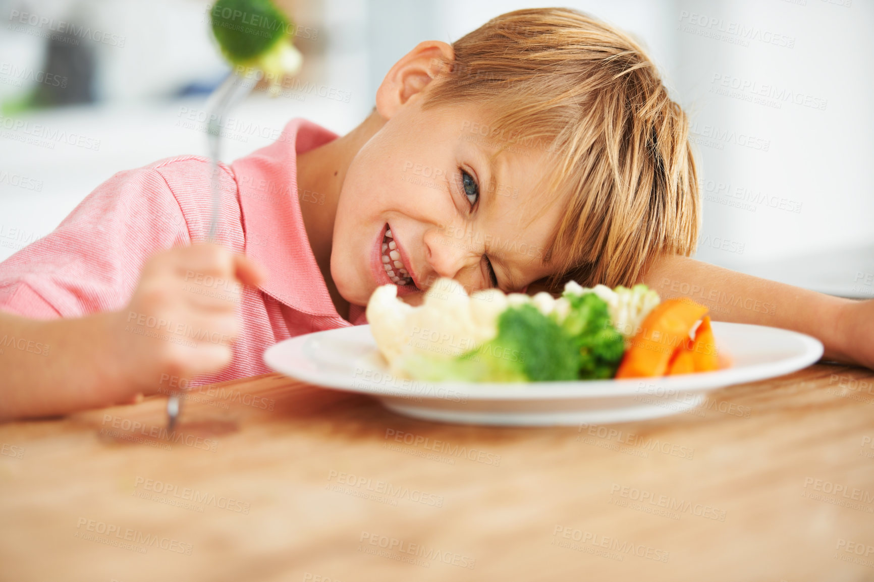 Buy stock photo Food, health and child eating vegetables for a healthy, growth and wellness diet at his home. Nutrition, dinner and boy kid laying on a dining table with produce lunch, snack or meal at his house.