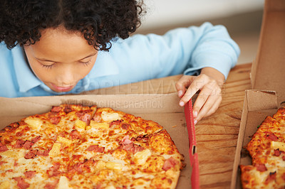 Buy stock photo Child, boy and pizza takeaway box for hungry snack, junk fast food dinner at kitchen table. Male person, kid and hawaiian pineapple bacon meal or joy reward eating or unhealthy diet, carbs for lunch