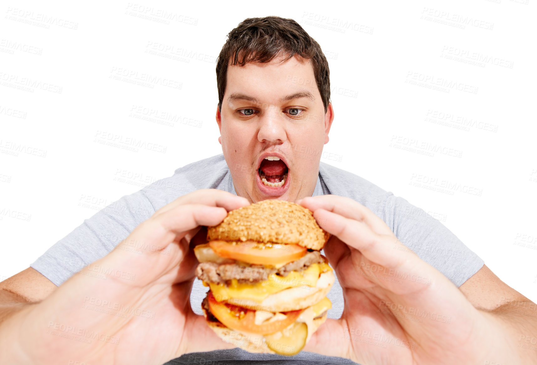 Buy stock photo An obese young man about to eat a huge hamburger