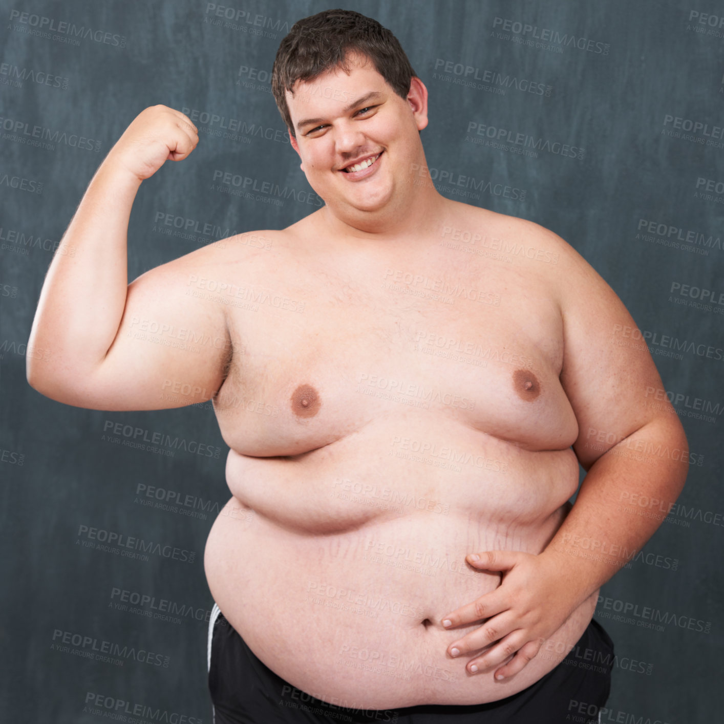 Buy stock photo Studio shot of an obese young shirtless man flexing his bicep