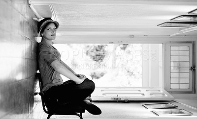 Buy stock photo A woman sitting on a chair inside her house with the house turned sideways - perspective