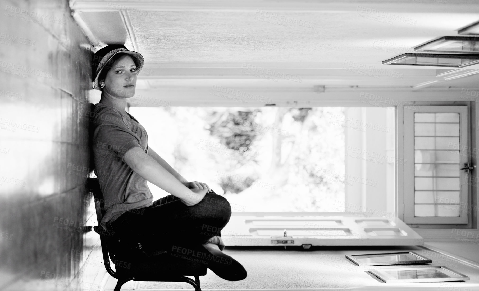 Buy stock photo A woman sitting on a chair inside her house with the house turned sideways - perspective
