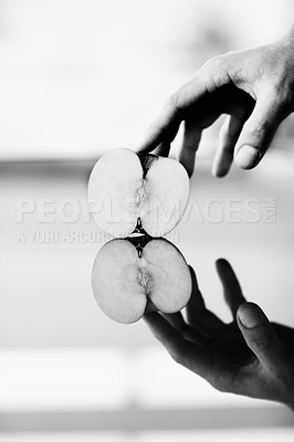 Buy stock photo A hand holding half an apple against a shiny surface  with it's reflection underneath