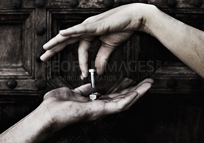 Buy stock photo A nut and bolt being put together by two hands