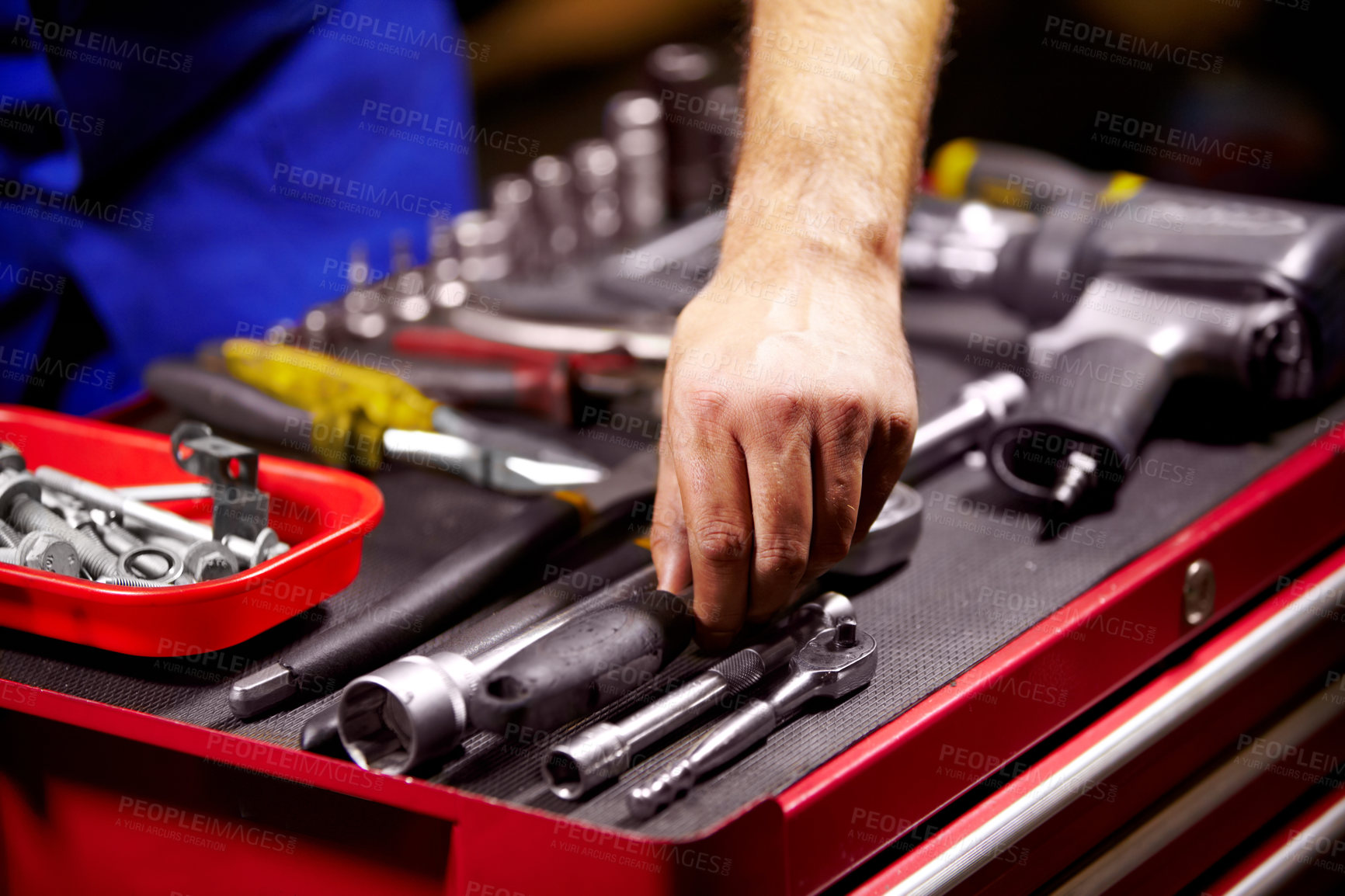 Buy stock photo Hand of a mechanic doing repairs after reaching for a wrench from his toolbox. Blue collar worker with the tool to fix your vehicle, perform a service or do maintenance. 