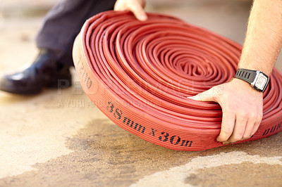 Buy stock photo Cropped image of a fireman's hands grabbing a firehose