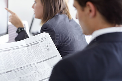 Buy stock photo Shot of two colleagues doing financial research at the office