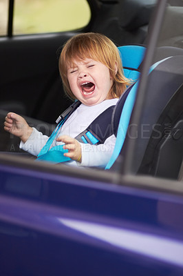 Buy stock photo A crying baby sitting in a carseat in a car