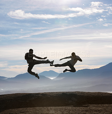 Buy stock photo Two male kickboxers fly kicking one another on a mountain top