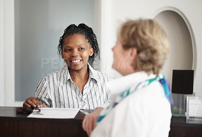 Buy stock photo A receptionist giving a senior woman the keys to her hotel room