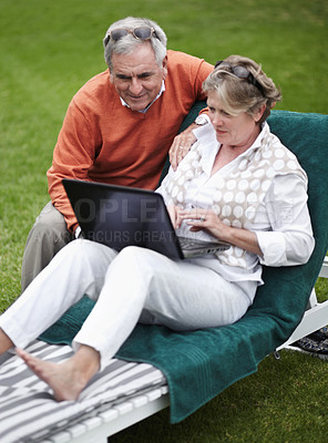 Buy stock photo Retirement, laptop and an old couple in the garden of a hotel for travel or vacation at a luxury resort. Love, technology or social media with a senior man and woman tourist on a deckchair at a lodge