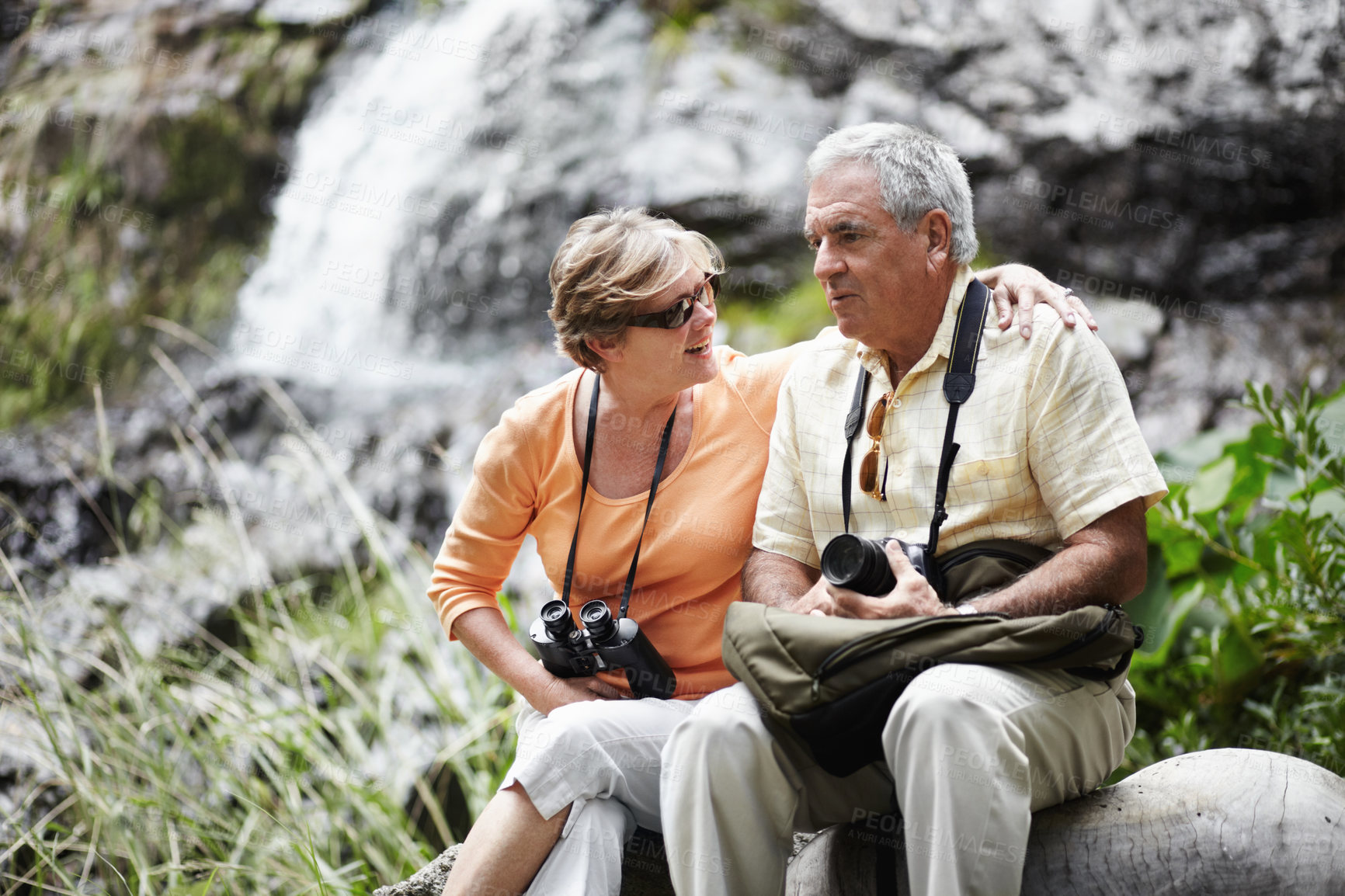 Buy stock photo A senior couple taking a break while out walking in the forest together