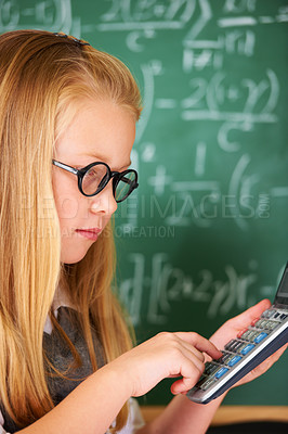 Buy stock photo Child, learning math and board in classroom for problem solving, typing numbers and calculation with glasses. Smart student or girl with calculator for education, knowledge and solution on chalkboard