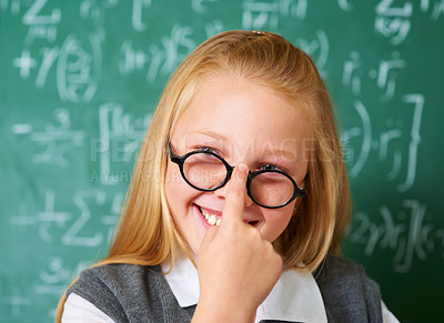 Buy stock photo Girl child, student with glasses and chalkboard for learning, education and to start math quiz in classroom. Happy face of smart, intelligent kid with vision, eye care and numbers on board for school