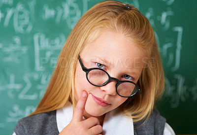 Buy stock photo Portrait of student, nerd and kid thinking by chalkboard in class for learning knowledge, education and study math. Face, glasses and geek at school, blonde girl and child in classroom in Switzerland