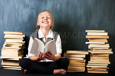 Buy stock photo Girl, classroom and kid reading book for education, language learning and knowledge on chalkboard background. Child or student on floor with books and story for school, English or literature portrait