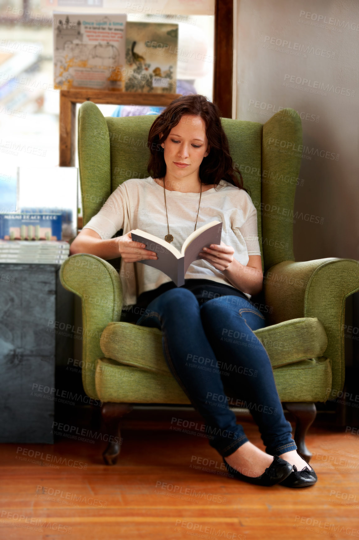 Buy stock photo Education, woman reading a book and sitting on a couch at a local bookstore. Research or learning, studying or research and female person read a textbook or notebook on a sofa for knowledge.