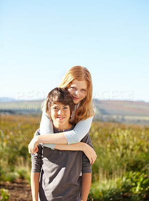 Buy stock photo Portrait of a young boy giving his sister a piggyback in the garden