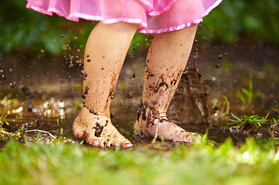Buy stock photo Shot of a little girl playing outside in the mud