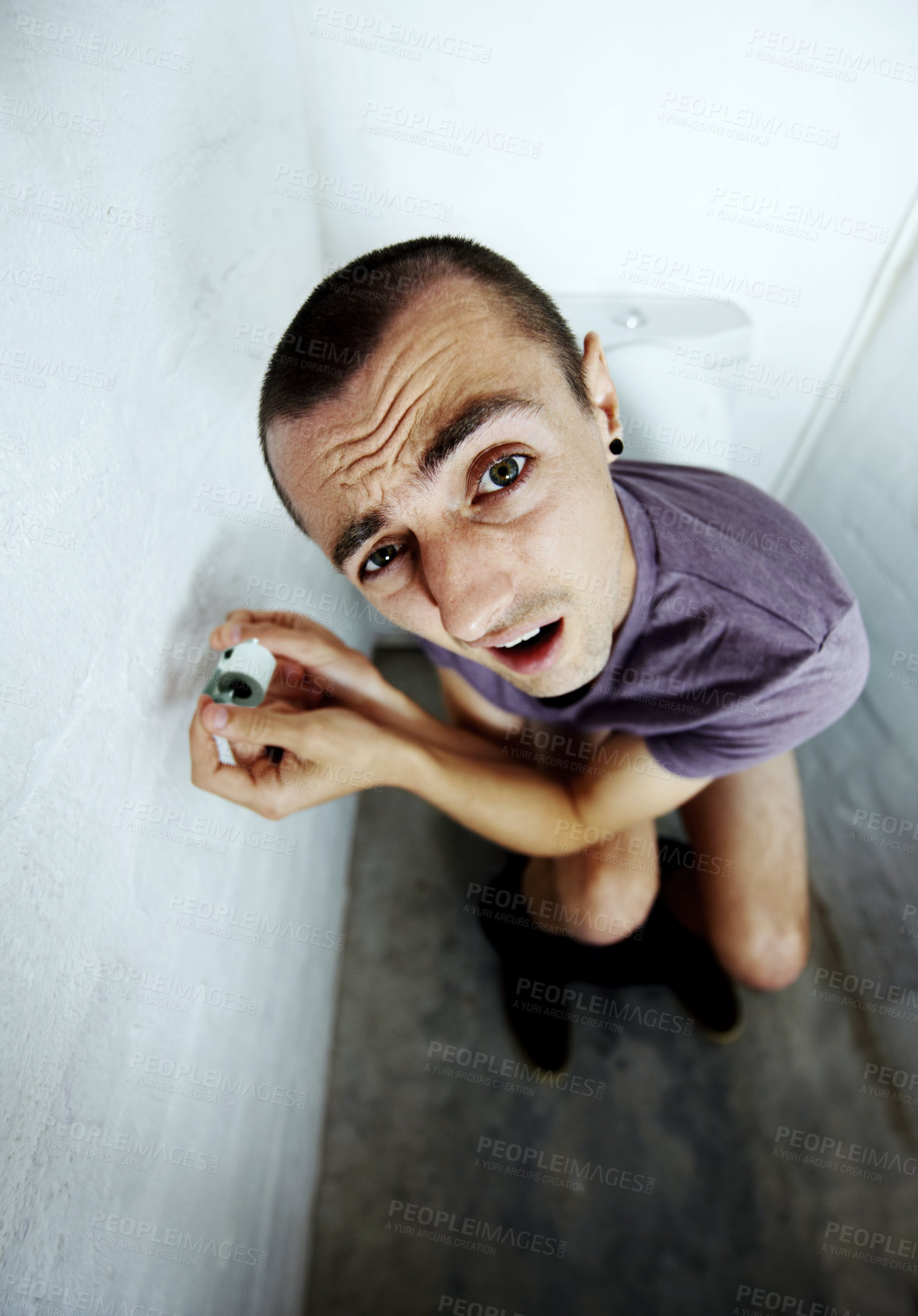 Buy stock photo A young man stuck in a toilet trying to reach a tiny roll of toilet paper