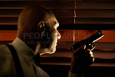 Buy stock photo Mob boss looking out through the blinds while holding a handgun