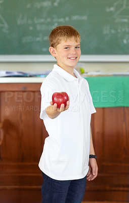 Buy stock photo Portrait, education and apple with a boy child in a classroom for learning, growth or development. Smile, kids and a happy young student in a class at school to study with a healthy fruit snack
