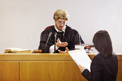 Buy stock photo Serious young judge sitting in the courtroom with a stern facial expression