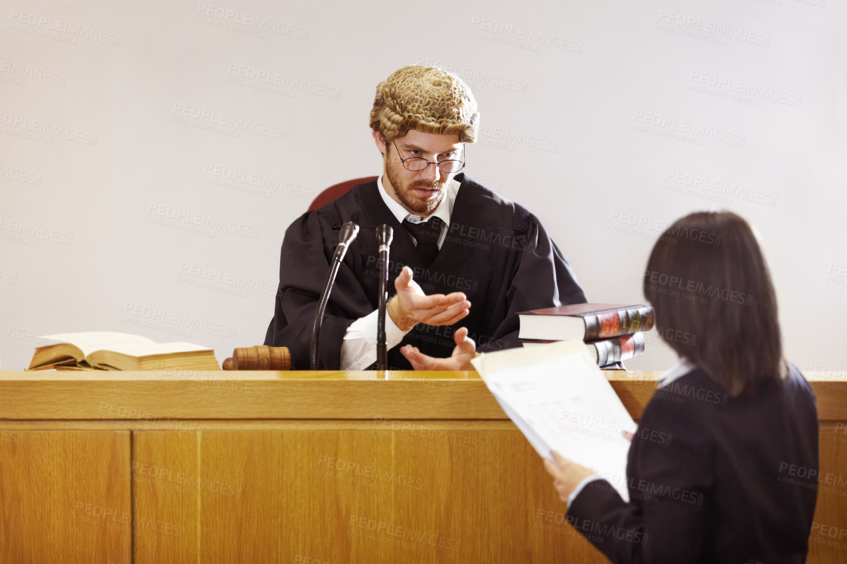 Buy stock photo Serious young judge sitting in the courtroom with a stern facial expression