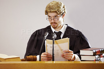 Buy stock photo Legal, documents and a judge man in court with trial evidence for a verdict to punish crime. Law, justice and glasses with a serious lord justice listening to proof or testimony for criminal sentence
